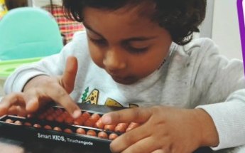 A child counting beads on a Smart Kids abacus