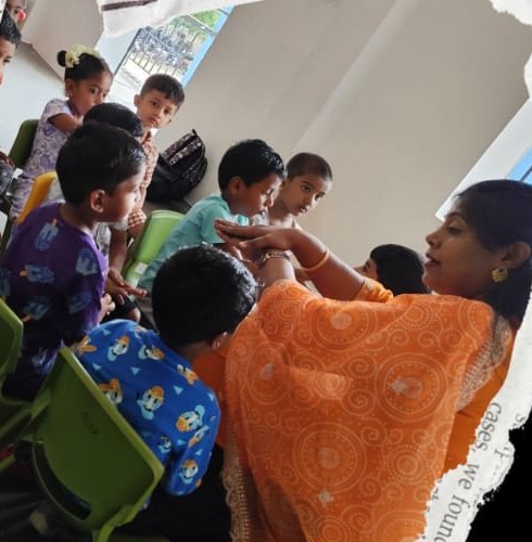 A teacher leading a group activity with children seated in a circle
