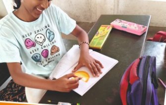 A girl doing a paper craft activity at her desk