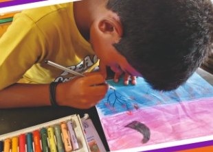 A boy painting a colourful landscape with oil pastels